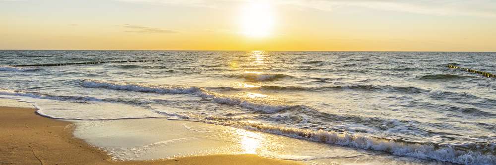 Urlaub am Meer - Sandstrand und Sonnenaufgang an der Ostseekste - Banner / Panoroma